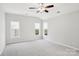 Bright bedroom with neutral walls and carpet, featuring multiple windows and a ceiling fan at 8720 Tamarron Dr, Charlotte, NC 28277