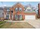 Two-story brick home with a large attached garage and manicured lawn at 8720 Tamarron Dr, Charlotte, NC 28277