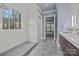 Spa-like bathroom with marble shower, grey floor tile, and a view into bedroom at 8928 Heydon Hall Cir, Charlotte, NC 28210