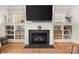 Living room fireplace with custom shelving, wood burning fireplace, natural light and hardwood floors at 907 Millbrook Rd, Charlotte, NC 28211