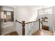 Upstairs hallway with hardwood floors, white railing, and natural light from a window at 907 Millbrook Rd, Charlotte, NC 28211