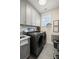 This laundry room features gray cabinets, washer, dryer, and stylish decor at 907 Millbrook Rd, Charlotte, NC 28211