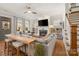 Bright living room with a ceiling fan, fireplace, TV, and ample natural light from large windows at 907 Millbrook Rd, Charlotte, NC 28211