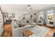 Spacious living room with hardwood floors, natural light, a large sectional sofa and views to the backyard at 907 Millbrook Rd, Charlotte, NC 28211