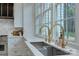 Modern kitchen with farmhouse sink, gold fixtures, and large windows at 961 Jw Wilson Rd, Fort Mill, SC 29715