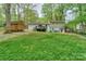 Large level backyard featuring a deck, patio, storage shed, and lush green grass at 170 Woodcrest Rd, Mooresville, NC 28115