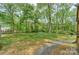 Large backyard lined with trees and a fence providing privacy, also features a gravel area at 170 Woodcrest Rd, Mooresville, NC 28115