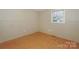 Empty bedroom features vinyl floors, neutral walls, and a bright window with natural light at 170 Woodcrest Rd, Mooresville, NC 28115
