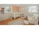 Bedroom with decorative wallpaper accent wall, crib, chair, and a large window with natural light at 170 Woodcrest Rd, Mooresville, NC 28115