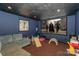Basement living room with projector screen and blue accent walls at 170 Woodcrest Rd, Mooresville, NC 28115