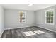 Bright bedroom with grey walls, wood-look flooring, and two large windows at 2091 & 2095 Catawba River Rd, Fort Lawn, SC 29714