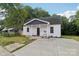 Charming exterior of a home with a inviting front porch, updated roof and a well-maintained lawn at 211 Brooklyn Ave, Lancaster, SC 29720