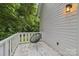 A modern chair sits on the porch with a view of the mature trees in the yard at 211 Brooklyn Ave, Lancaster, SC 29720