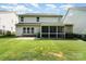 Large backyard with green grass, a stone patio, screened in porch, and fenced yard at 2201 Bluebell Way, Tega Cay, SC 29708