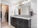 Bathroom featuring a double vanity with granite countertop and a view into the walk-in closet at 2201 Bluebell Way, Tega Cay, SC 29708
