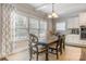 Dining area with a rustic wooden table, light walls and large windows, creating a bright and inviting space at 2201 Bluebell Way, Tega Cay, SC 29708