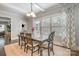 Bright dining area with a wooden table, large windows with patterned curtains, and modern lighting fixtures at 2201 Bluebell Way, Tega Cay, SC 29708