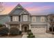 Traditional home showcasing detailed trim, a cozy porch, and an attached two-car garage at 2201 Bluebell Way, Tega Cay, SC 29708