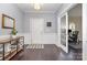 Inviting foyer with dark hardwood floors, wainscoting detail, and view to a home office at 2201 Bluebell Way, Tega Cay, SC 29708