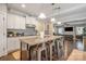 Spacious kitchen island with bar seating, white cabinets, pendant lighting, and stainless steel appliances at 2201 Bluebell Way, Tega Cay, SC 29708