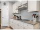 This kitchen features white cabinets, granite countertops, subway tile backsplash and stainless steel hood at 2201 Bluebell Way, Tega Cay, SC 29708