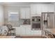 Bright kitchen features white cabinetry, stainless steel appliances and eat-in counter with granite countertops at 2201 Bluebell Way, Tega Cay, SC 29708