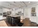 Well-lit kitchen featuring a dark island, stainless steel appliances, white cabinets, and stylish barstool seating at 2201 Bluebell Way, Tega Cay, SC 29708