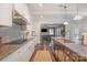 Bright, open kitchen showcasing granite countertops, white cabinets, and seamless flow into the living area at 2201 Bluebell Way, Tega Cay, SC 29708
