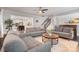 Open-concept living room with hardwood floors, access to kitchen, staircase, and front foyer at 2201 Bluebell Way, Tega Cay, SC 29708