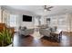 Bright living room featuring hardwood floors, ceiling fan, and multiple windows with neutral drapes at 2201 Bluebell Way, Tega Cay, SC 29708