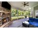 Relaxing screened-in porch featuring a stone fireplace, comfortable seating, and views of the lush backyard at 2201 Bluebell Way, Tega Cay, SC 29708
