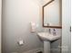 Small bathroom with pedestal sink, mirror, and modern fixtures at 2401 Euclid Ave # 110, Charlotte, NC 28203