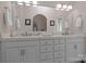 Bathroom featuring double vanity sinks with modern fixtures, white cabinets, and a large mirror at 2498 Smith Harbour Dr, Denver, NC 28037