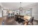 Bright dining room features a long wood table, black chairs, and an elegant light fixture at 3041 Winged Teal Ct, Belmont, NC 28012