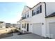 White house with black windows, a front porch, and a two-car garage at 3139 Pinehills Way, Mount Holly, NC 28120