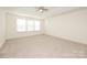 Main bedroom with ceiling fan, large windows, and carpet at 3139 Pinehills Way, Mount Holly, NC 28120