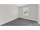 Bright bedroom with grey carpet and a window offering natural light at 3273 Bending Birch Pl, Charlotte, NC 28206