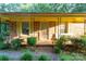 Charming brick home featuring a covered front porch with mature landscaping and a secure front door at 3581 Thompson St, Newton, NC 28658