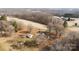 Wide aerial shot of a charming farmhouse and white shed, nestled among serene fields and bare trees, revealing rural tranquility at 40503 Millingport Rd, Richfield, NC 28137