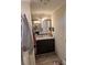Bathroom vanity with mirror, dark cabinets, neutral countertop, and wood-look vinyl flooring at 5122 Wrenn Dr, Denver, NC 28037