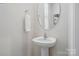 Bathroom featuring a pedestal sink, round mirror, and clean, modern design at 604 Cassidy Ct, Clover, SC 29710
