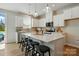 Bright kitchen featuring a large island with bar seating, white cabinets, and modern lighting at 604 Cassidy Ct, Clover, SC 29710