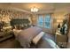Serene main bedroom featuring a king-sized bed, stylish wallpaper, and soft lighting, creating a relaxing retreat at 616 Cassidy Ct, Clover, SC 29710