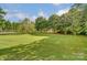 Large, lush backyard featuring mature trees, a well-maintained lawn, and a fenced perimeter for privacy at 712 Springwood Dr, Waxhaw, NC 28173