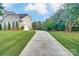 Long driveway leading to a well-maintained home with a spacious, green lawn and mature trees at 712 Springwood Dr, Waxhaw, NC 28173