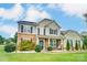 Inviting two-story home with stone and siding, manicured lawn, and covered front porch at 712 Springwood Dr, Waxhaw, NC 28173