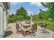 Spacious stone patio with multiple seating areas, a grill, and lush landscaping in the backyard at 712 Springwood Dr, Waxhaw, NC 28173