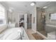 This bright bathroom features a soaking tub, glass shower, double sinks, and an opening to the bedroom at 840 Pecan Tree Ln, Fort Mill, SC 29715