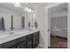 This bathroom includes double sinks with black cabinetry and a view into the bedroom at 840 Pecan Tree Ln, Fort Mill, SC 29715