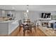 Bright dining room with fireplace, modern lighting, and wood floors at 1077 Gauguin Ln, Tega Cay, SC 29708